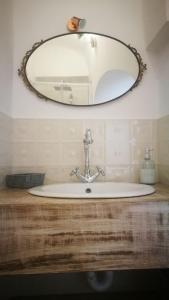 a bathroom sink with a mirror on the wall at Solis Domus - Meridies in Ostuni