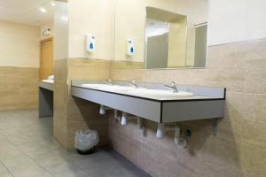 a bathroom with a sink and a mirror at Hostal Los Gabrieles in Albacete