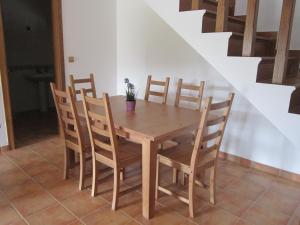 Xaviña Camariñas في كامارينياس: طاولة وكراسي خشبية في غرفة بها درج