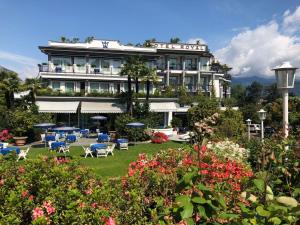 um hotel com um jardim com cadeiras e flores em Hotel Royal em Stresa