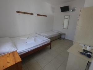 Habitación pequeña con 2 camas y espejo. en Merhaba Pansiyon en Bodrum