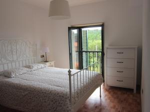 biała sypialnia z łóżkiem i oknem w obiekcie Xaviña Camariñas w mieście Camariñas