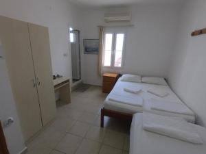 1 dormitorio con 2 camas, escritorio y ventana en Merhaba Pansiyon, en Bodrum City