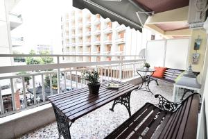 - un balcon avec une table et un banc en bois dans l'établissement Queens Bed&Rest Luxury Apartment, à Kavala