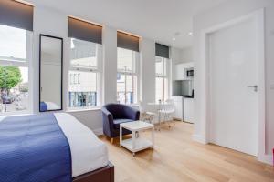 ロンドンにあるChapel Market Serviced Apartments by Concept Apartmentsのベッドルーム1室(ベッド1台、椅子、テーブル付)