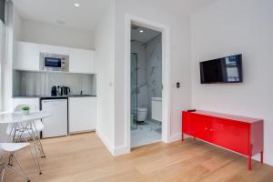 una cucina con cassettiera rossa in una camera di Chapel Market Serviced Apartments by Concept Apartments a Londra