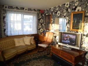 a living room with a couch and a television at Kuressaare White Villa in Kuressaare