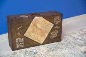 a brown suitcase sitting on a counter with stickers on it at Hotel Mica in Palas de Rei