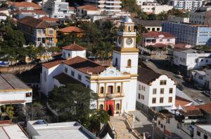 un antiguo edificio con una torre de reloj en una ciudad en Hotel Central Parque, en São Lourenço