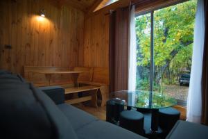 a living room with a glass table and a large window at Cabañas Huilipan in Las Trancas