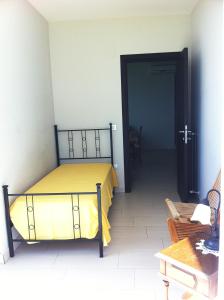 1 dormitorio con 1 cama con manta amarilla en Appartamento Malvarosa, en Colonnella