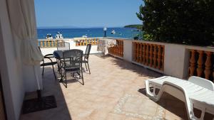 a balcony with chairs and tables and a view of the ocean at Apartmani Marenda in Supetarska Draga