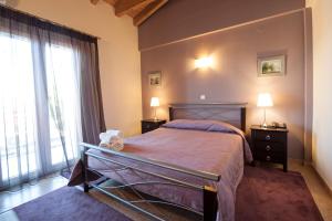 a bedroom with a bed with two night stands and two lamps at Iliothea in Nafplio