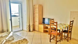 a room with a table and a television and a bedroom at Obala Apartment & Studios in Malinska +19 photos