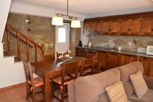 a kitchen and dining room with a table and a couch at Casa do Chão do Ribeiro in Gouveia