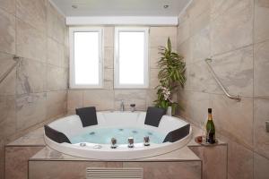 un bagno con grande vasca e 2 finestre di Hotel Perekop a Berdorf