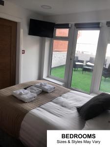a bedroom with a large bed with pillows and windows at Seafront419 By Seafront Collection in Blackpool