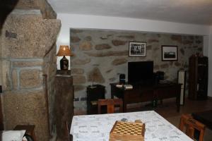 uma sala de estar com uma mesa e uma secretária com um tabuleiro de xadrez em Alojamento Rural Casa da Eira em Murça