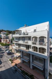 een wit appartementencomplex met balkons en een parkeerplaats bij Sea and the city in Rhodos-stad