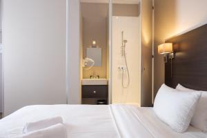 a bedroom with a white bed and a shower at Best Budget Rooms in Brussels