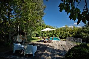 a pool with a table and chairs and an umbrella at Casa De Alfena in Póvoa de Lanhoso