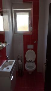 a bathroom with a toilet and a window and a sink at Apartmani Marenda in Supetarska Draga +45 photos