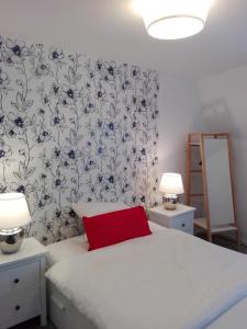 トラーベン・トラーバッハにあるFerienwohnung Burgblickのベッドルーム1室(白いベッド1台、赤い枕付)