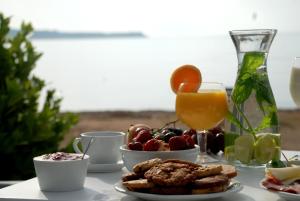 a table with a plate of food and a glass of orange juice at Casa Montzo boutique hotel in Katelios