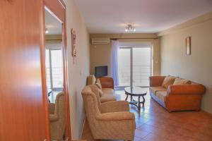 een woonkamer met een bank en stoelen en een televisie bij Ana in Budva