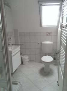 a white bathroom with a toilet and a sink at Anbau in Evestorf