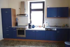 a kitchen with blue cabinets and a window at Ferienwohnung Burgblick in Traben-Trarbach