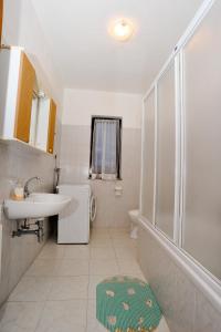 biała łazienka z umywalką i prysznicem w obiekcie Guest House Krševan w mieście Zadar