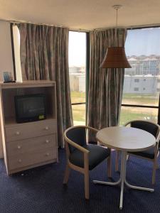 a hotel room with a table and chairs and a television at Bal Harbour Hotels in Wildwood Crest