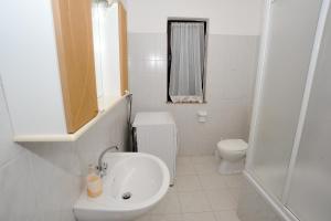 Baño blanco con lavabo y aseo en Guest House Krševan en Zadar