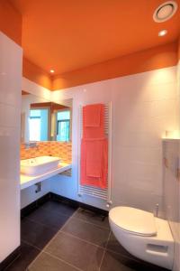 an orange bathroom with a toilet and a sink at Sant’Andrea Penthouse in Menaggio