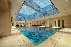 泰州的住宿－泰州國際金陵大酒店，一座建筑物的地板上有一个画作的游泳池