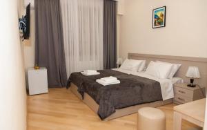 1 dormitorio con 1 cama con 2 toallas en Holiday Rooms en Tiflis