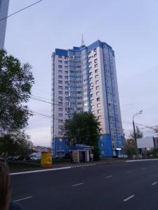 サランスクにあるApartment on Volgogradskaya 64の通路脇の高い青い建物
