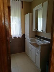 a bathroom with a sink and a mirror at Chalet vacacional en segunda linea de playa in Foz