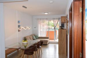 un soggiorno con tavolo in vetro e divano di Caleta Relax - Apartamento Fuerteventura Apartment a La Oliva