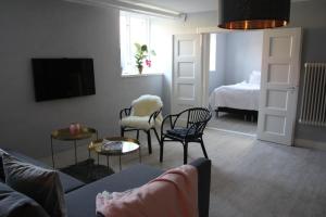 a living room with a couch and chairs and a bed at Charmigt i centrala Ystad in Ystad