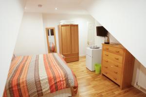 1 dormitorio con 1 cama, vestidor y TV en Homeside B&B en Silverstone
