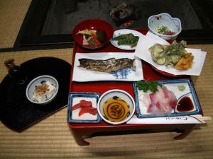 a table filled with different types of food on it at Minshuku Yomoshirou in Nanto