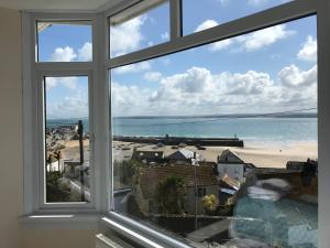 a window with a view of a beach and the ocean at Palma Guest House in St Ives