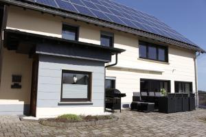 une maison avec des panneaux solaires sur le toit dans l'établissement Ferienhaus "Am Backes", à Gefell