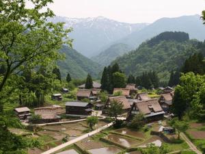 ein Dorf in einem Tal mit Bergen im Hintergrund in der Unterkunft Minshuku Yomoshirou in Nanto