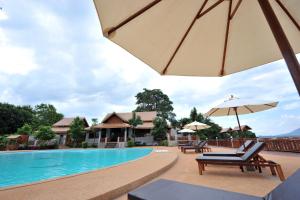 una piscina in un resort con sedie e ombrellone di Arawan Riverside Hotel a Pakse