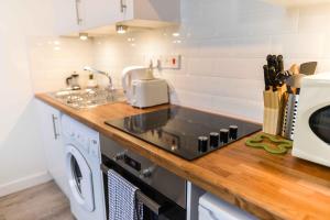 una cocina con fregadero y estufa horno superior en Stafford Modern Apartment, en Aberdeen