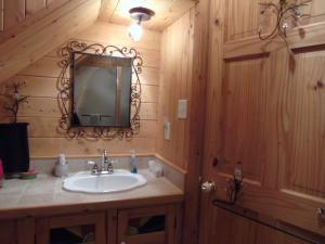La salle de bains est pourvue d'un lavabo et d'un miroir. dans l'établissement Gîte la Veilleuse, à Saint-Georges-de-Cacouna