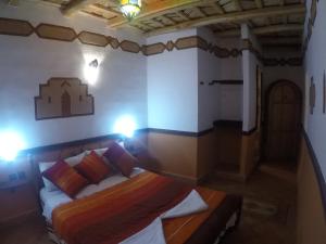 a bedroom with a bed and lights on the wall at Auberge des peupliers Café Restaurant in Akhendachou nʼAït Ouffi